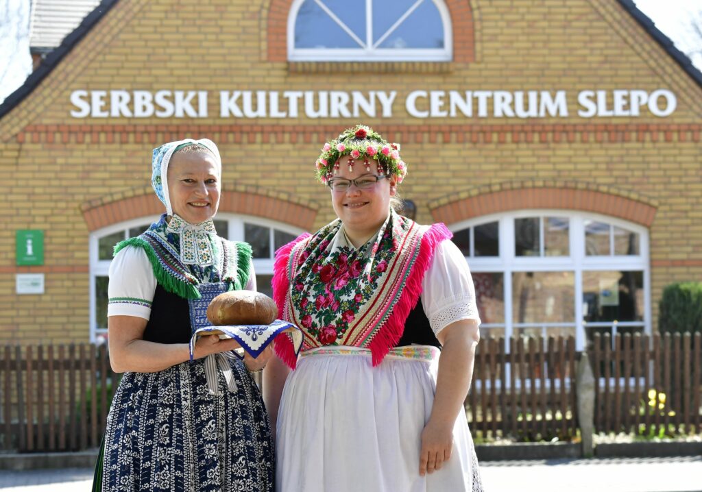 Zwei Frauen in Sorbischer Tracht vor dem Kulturzentrum Schleife